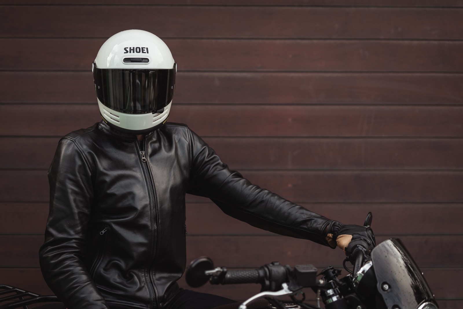 Person wearing Shoei Glamster helmet on motorcycle
