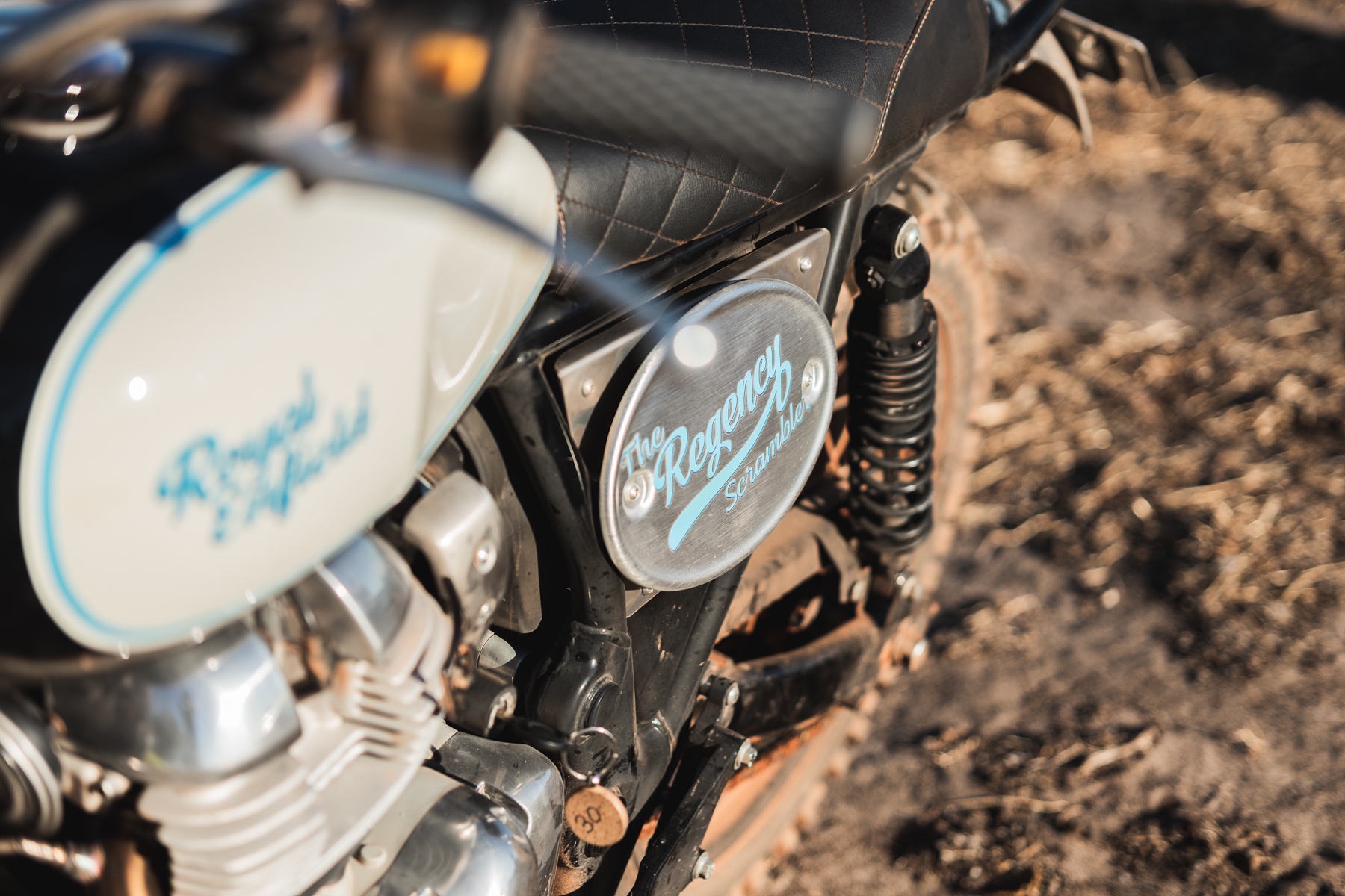 Close up detail photo of a Royal Enfield scrambler motorcycle side panel with painted lettering