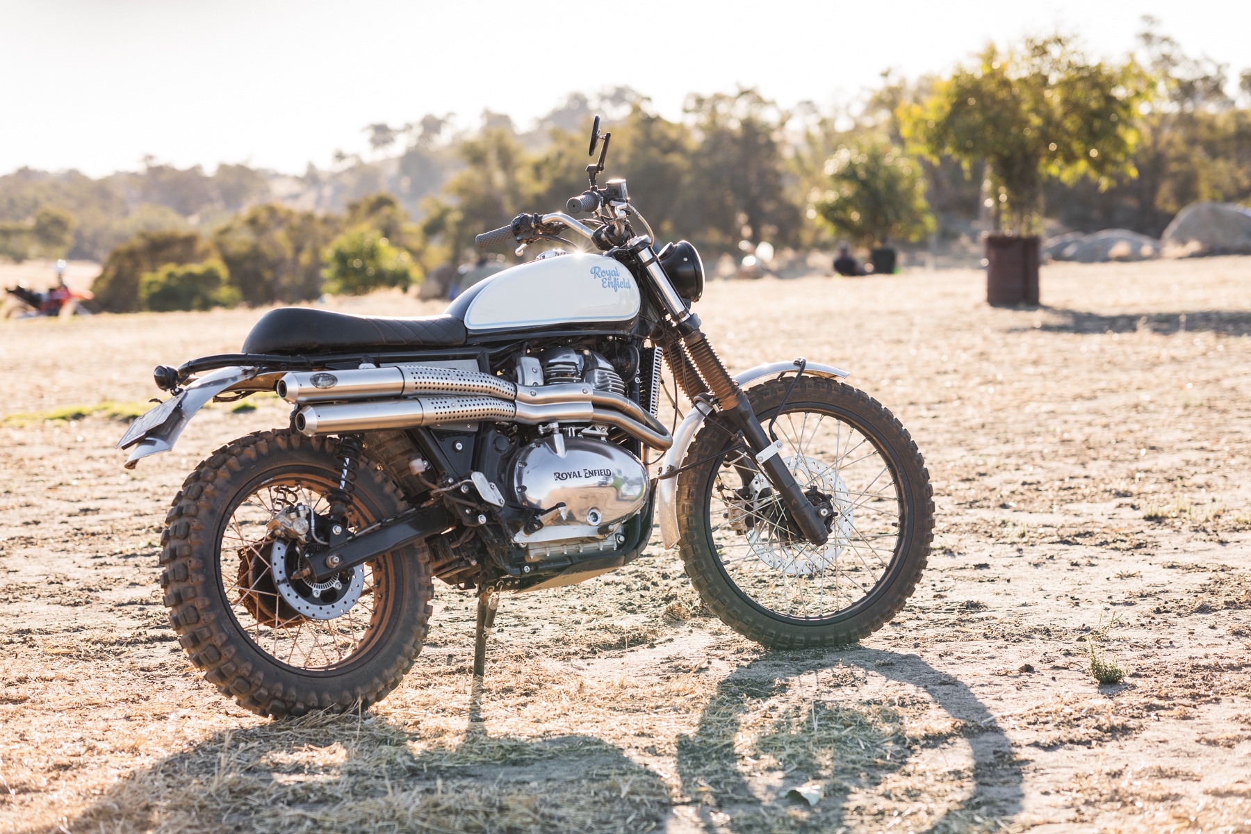 Side photo of a Royal Enfield scrambler motorcycle in a paddock